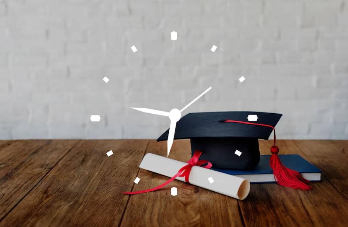 A graduation cap and rolled diploma with a red ribbon sit on a wooden table, symbolizing achievement and time.