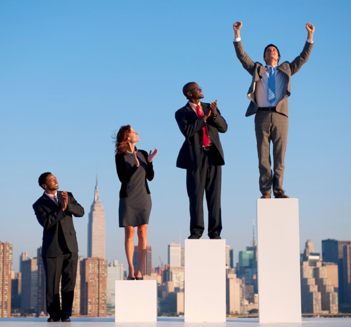 A group of four businesspeople stand on rising platforms, celebrating success against a city skyline backdrop.